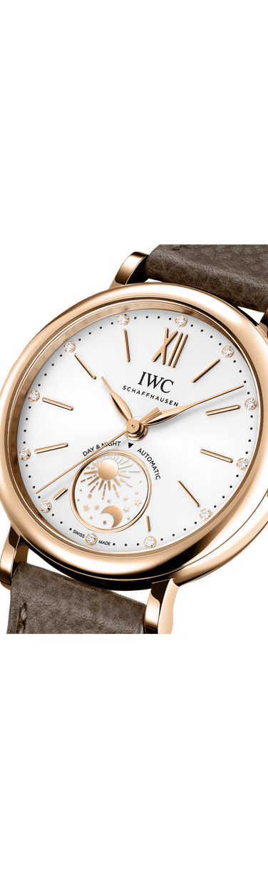 Close up image of IWC Portofino Automatic Day & Night with white dial, gold case and brown leather strap.