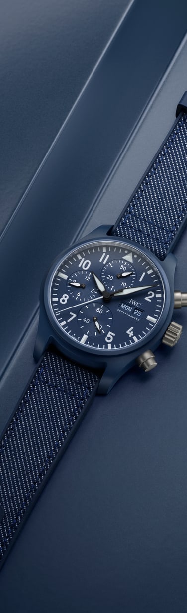 Close-up of a wrist wearing a watch with a textile strap, paired with a light-colored long-sleeve shirt.