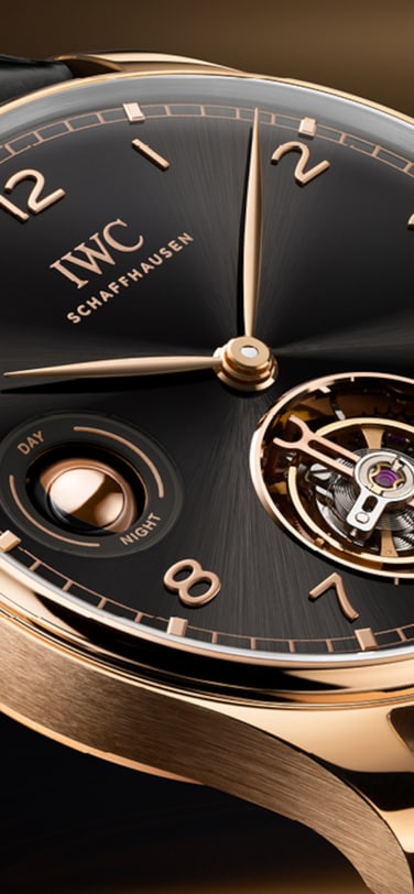 IWC Portugieser Tourbillon Remontage Manuel Jour & Nuit avec un cadran noir, un boîtier en Armor Gold® 18 carats et un bracelet en alligator noir de Santoni.