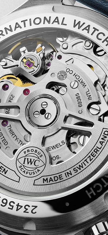 Eine Nahaufnahme der Rückseite einer IWC Schaffhausen Pilot's Watch, die den transparenten Gehäuseboden mit ihrem mechanischen Automatikwerk zeigt.