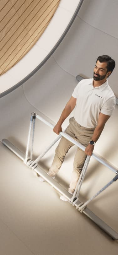 A man exercising in microgravity inside a space station with a domed window behind him showing a view of Earth's surface.