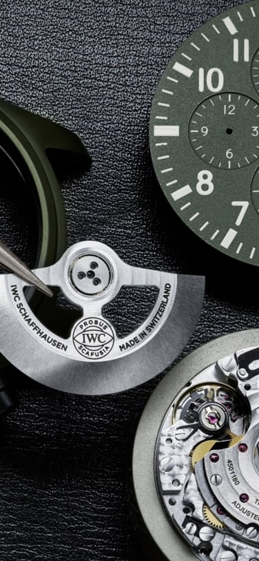 Close up of hands putting together parts of a green watch dial and case with calibre 69380