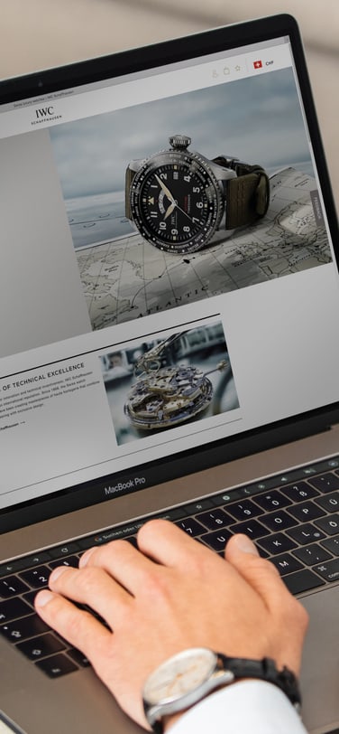 Man working in laptop with screen displaying an IWC webpage