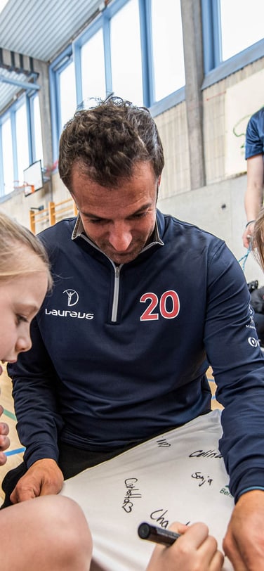 Children signing a T-Shirt with a black marker pen