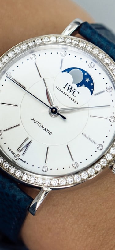 Gros plan d’une montre à phases de lune avec une lunette sertie de diamants