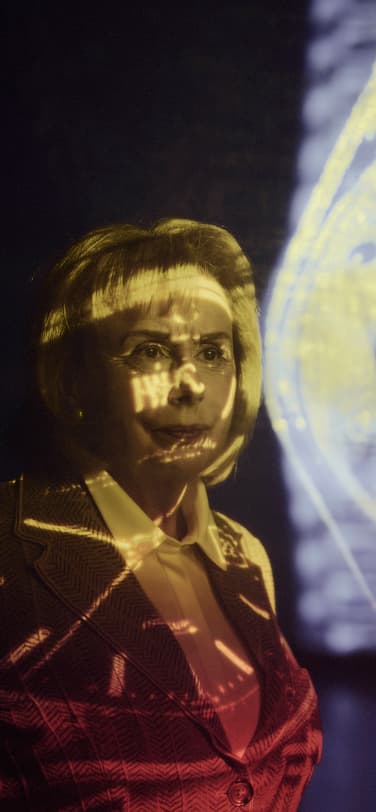 A woman, Evelyne Genta, standing in front of a projection of the 1976 Ingenieur SL