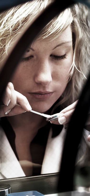 Young woman in white uniform assembling an IWC watch in manufacture environment