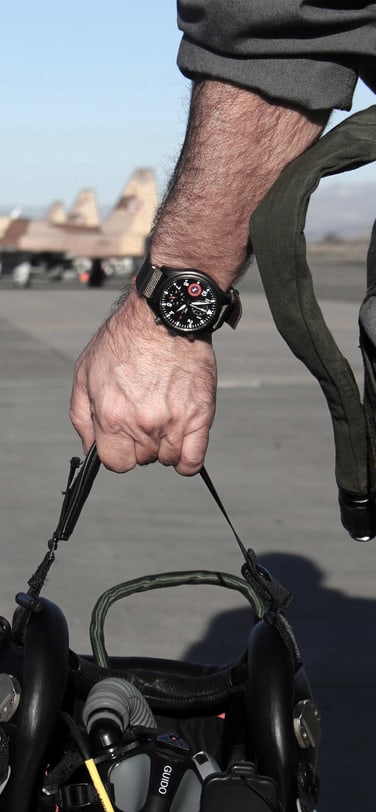 The Pilot’s Watch Chronograph TOP GUN Edition “SFTI” (Ref. IW389104) worn by a pilot holding a flight helmet