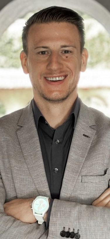 Young man in gray blazer and crossed arms wearing a white watch