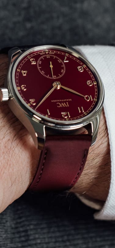 Wrist of man with grey pullover wearing the IW358315 Portugieser Automatic 40 Edition “Chinese New Year” with Red dial, Steel Case and black calfskin strap