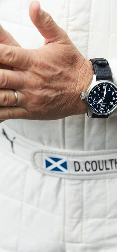 Close up wrist shot of a black Big Pilot’s Watch worn by driver David Coulthard.