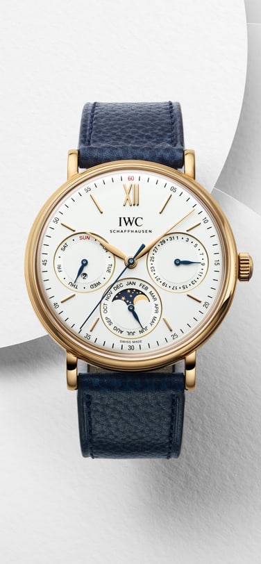 IWC portofino perpetual calendar watch with white dial, gold case and blue strap on a white background