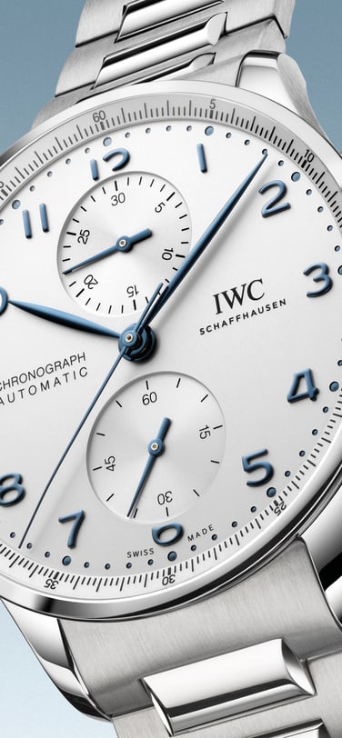 IWC Portugieser Chronograph IW371617; grey dial, blue Arabic numerals, stainless steel bracelet, against a light blue abstract background.