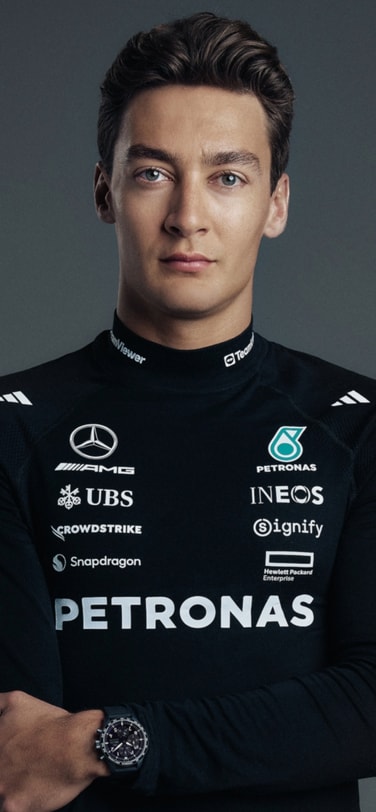 Grand Prix-winner and IWC brand ambassador George Russell in black uniform with brand logos wearing IWC watch