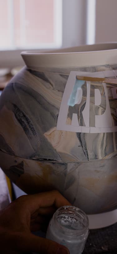 Ceramicist Laurin Schaub applying photoluminescent Ceralume glaze on the vessel