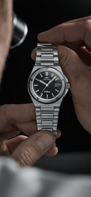 A man holding IWC Ingenieur watch with black dial and steel bracelet in his hands