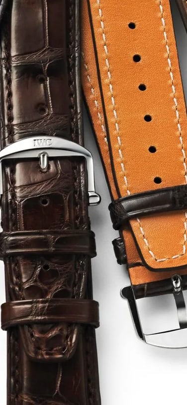 Plusieurs montres IWC avec des bracelets bleu, noir et rouge sur un fond blanc