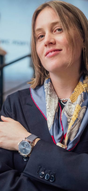 Brynn Wallner wearing a silk scarf and chronograph watch with blue dial and strap, and 18 carat white gold case