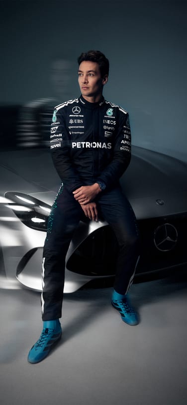 喬治·羅素(George Russell)身穿Mercedes-AMG PETRONAS一級方程式賽車服，置身黑色背景。