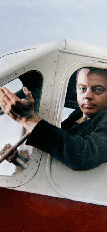Color photo of Antoine de Saint-Exupéry sitting in the sun