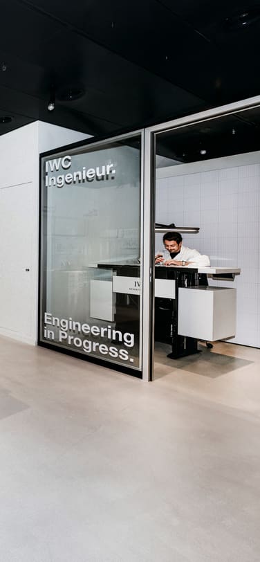 Person posing next to a vintage Braun FS 80-1 television designed by Dieter Rams, displaying an IWC watch, at the IWC Ingenieur Residency