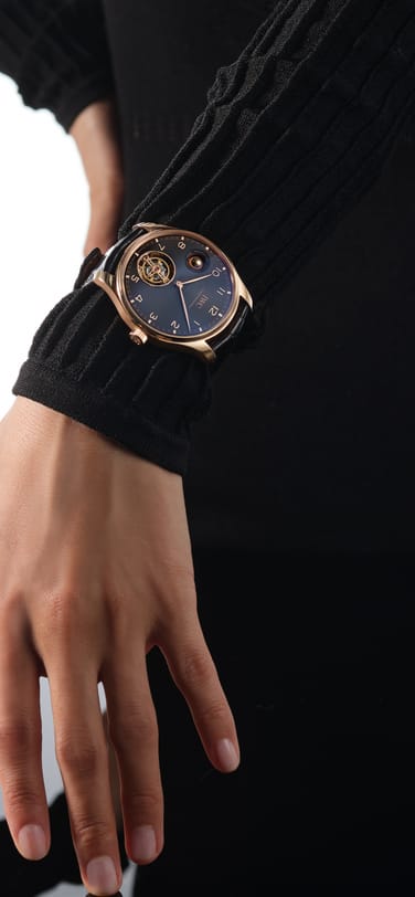 Front shot of IWC Portugieser Hand-Wound Tourbillon Day & Night with black dial, 18 ct Armor Gold® Case and black alligator leather strap by Santoni on a woman's wrist