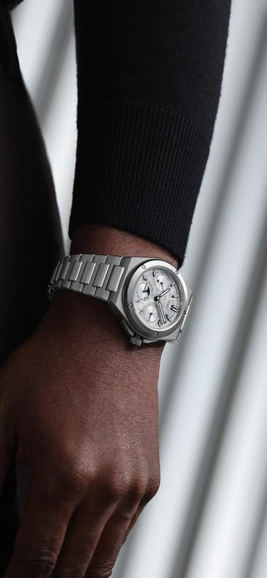 A silver Ingenieur watch on a wrist against a dark outfit