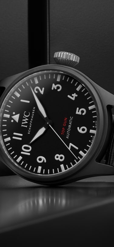 Front image of a black dial watch with a black textile strap.