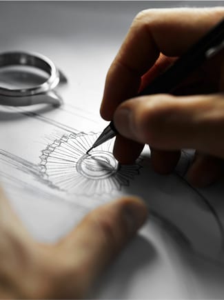 A hand holding a pencil draws a sketch of a watch