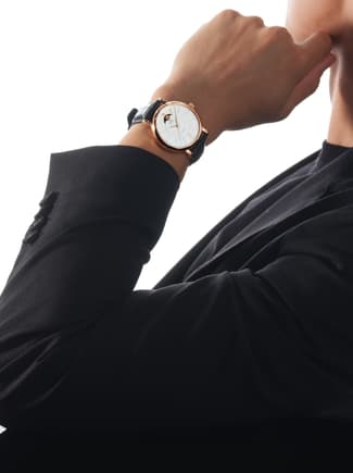 IWC Portofino watch with white dial, gold case and blue strap on a man's wrist