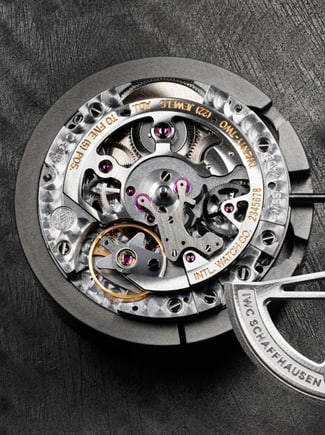 Thumbnail image link displaying a watch that is being serviced with a piece held by a set of tweezers