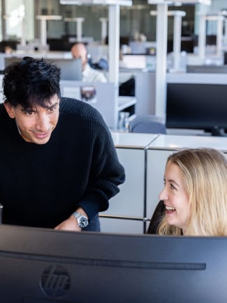 Two people at an office looking at a computer screen