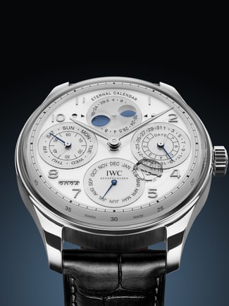 Front image showcasing the Eternal Calendar Watch with white dial and black strap on dark blue gradient background