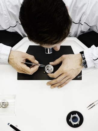 Thumbnail image link of man servicing a watch from above