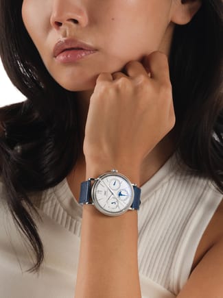 IWC Portofino watch with white dial and blue strap on a woman's wrist