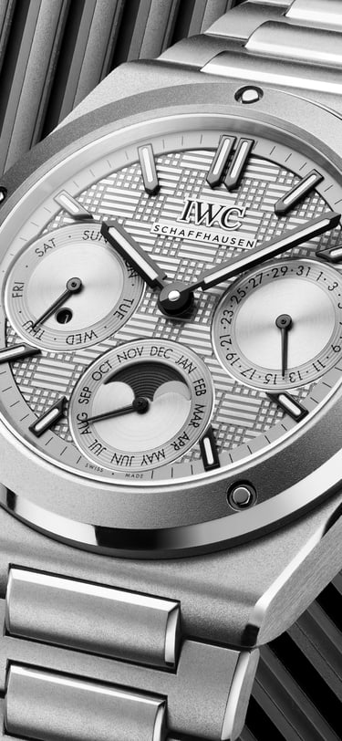 IWC Ingenieur Perpetual Calendar 41 in titanium with grey dial and integrated titanium bracelet, set against a geometric striped background