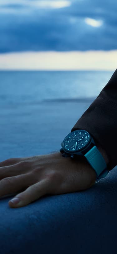 George Russell overlooking the ocean wearing the Pilot's Watch Chronograph 41 George Russell watch on his wrist.