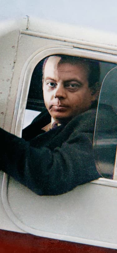 Antoine De Saint-Exupéry sitting inside an old aircraft in the pilot seat
