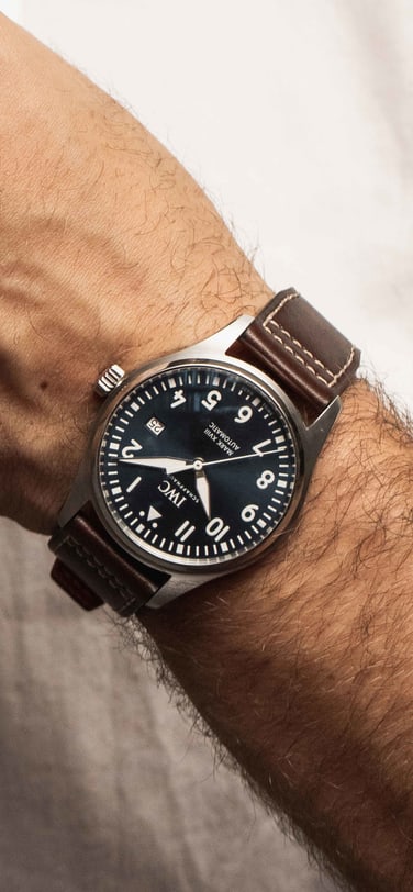 Close-up image of Anderas Weinas wearing IWC Pilot's Watches with a black dial and brown leather strap