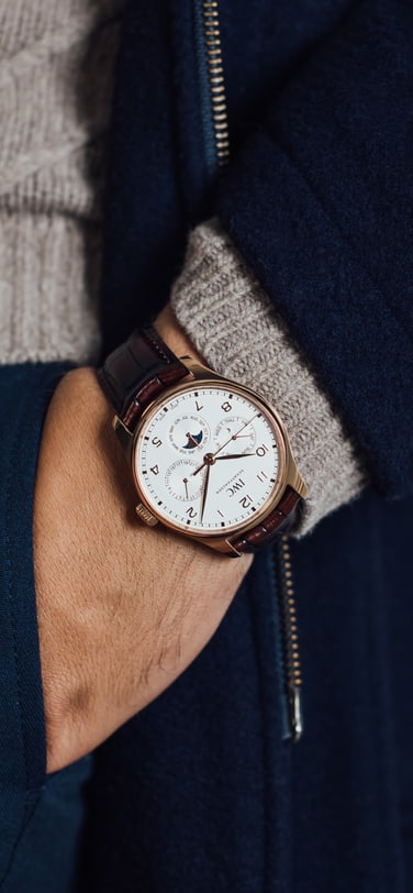 IWC Portugieser Perpetual Calendar with white dial and brown strap on a man's wrist
