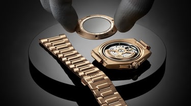 Mains plaçant un cadran noir sur la complication de l’IWC Portugieser Perpetual Calendar&nbsp;44 posée sur une surface foncée.