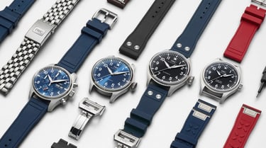 Plusieurs montres IWC avec des bracelets bleu, noir et rouge sur un fond blanc