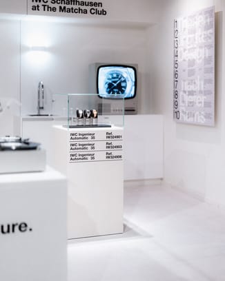 Display at the IWC Ingenieur Residency featuring IWC watches, a vintage television, and minimalist design elements.