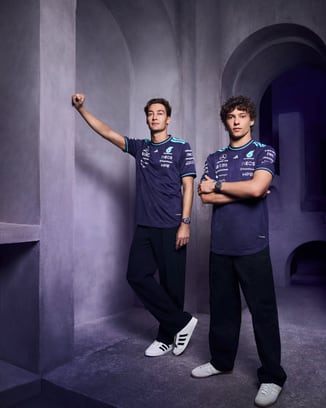 George Russell and Kimi Antonelli standing modelling IWC watches, Petronas shirts, and Addidas sneakers.