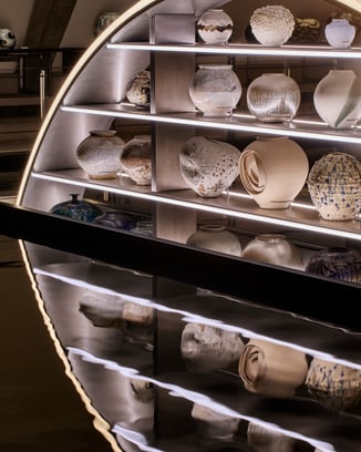 Shelf featuring moon jars in different sizes, materials and colors.