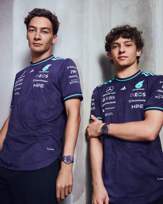 George Russell (L) and Kimi Antonelli (R) wearing Petronas Team shirts and Pilot's Watch Chronograph 41 Mercedes-AMG Petronas Formula One™ Team watch.