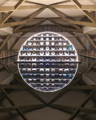 Art installation of moon jars in front of a reflecting pool.