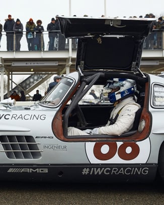 A silver Mercedes-Benz SL 300 “Gullwing” on the race track.