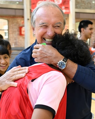 Ein Mann in heller Kleidung schwingt einen Golfschläger auf einem Golfplatz, im Hintergrund IWC-Banner.