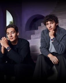 George Russell (L) and Kimi Antonelli (R) sitting modelling Pilot's Watch Chronograph 41 Mercedes-AMG Petronas Formula One™ Team watches.